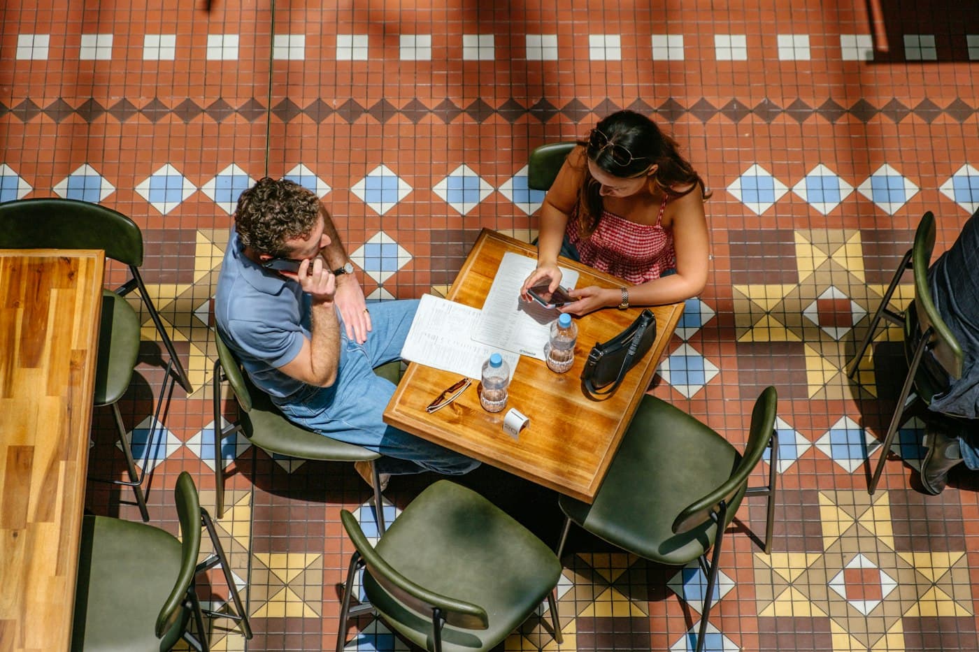 Two people studying at a tiled café table