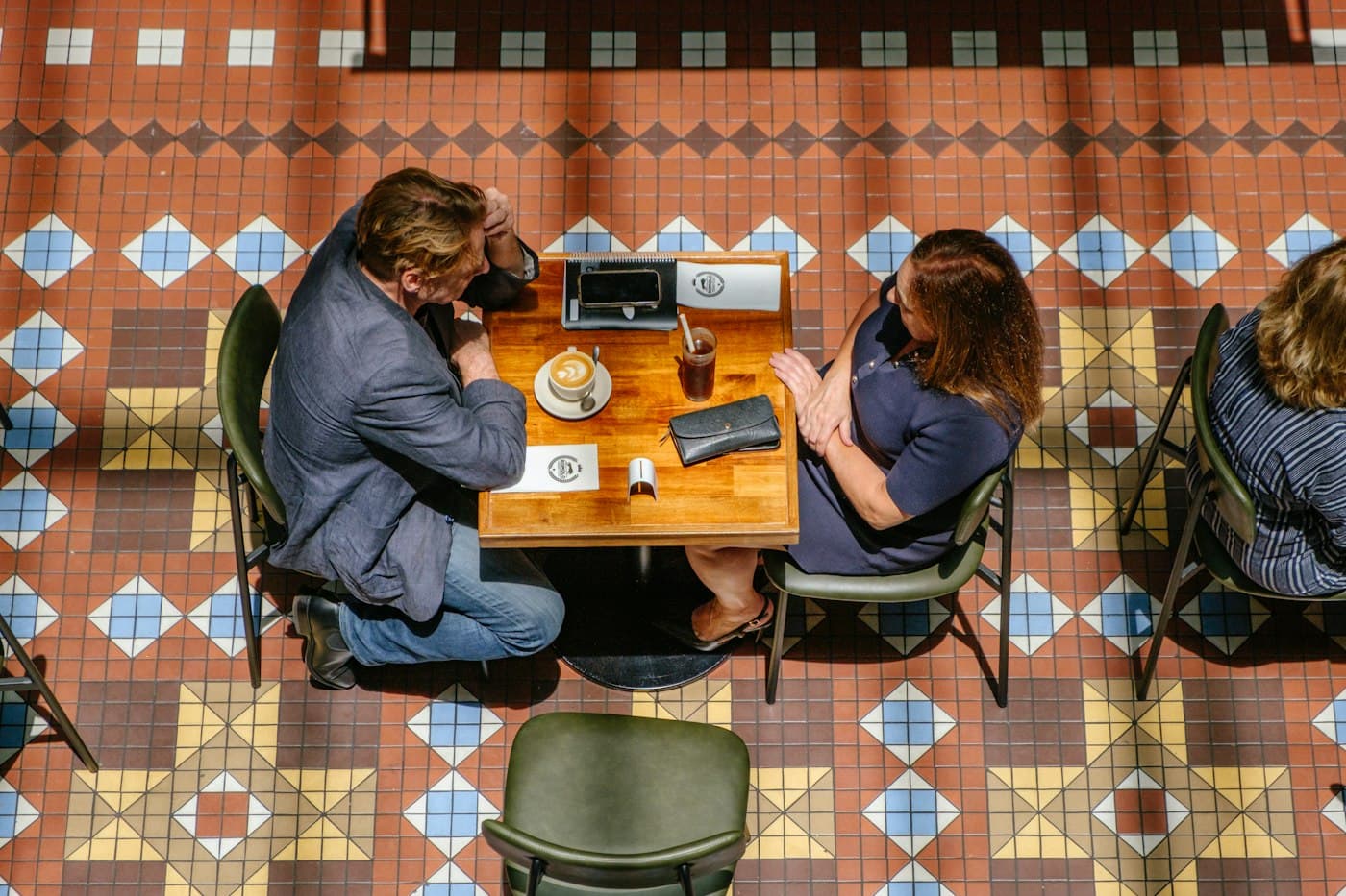 Two people working on laptops in a café