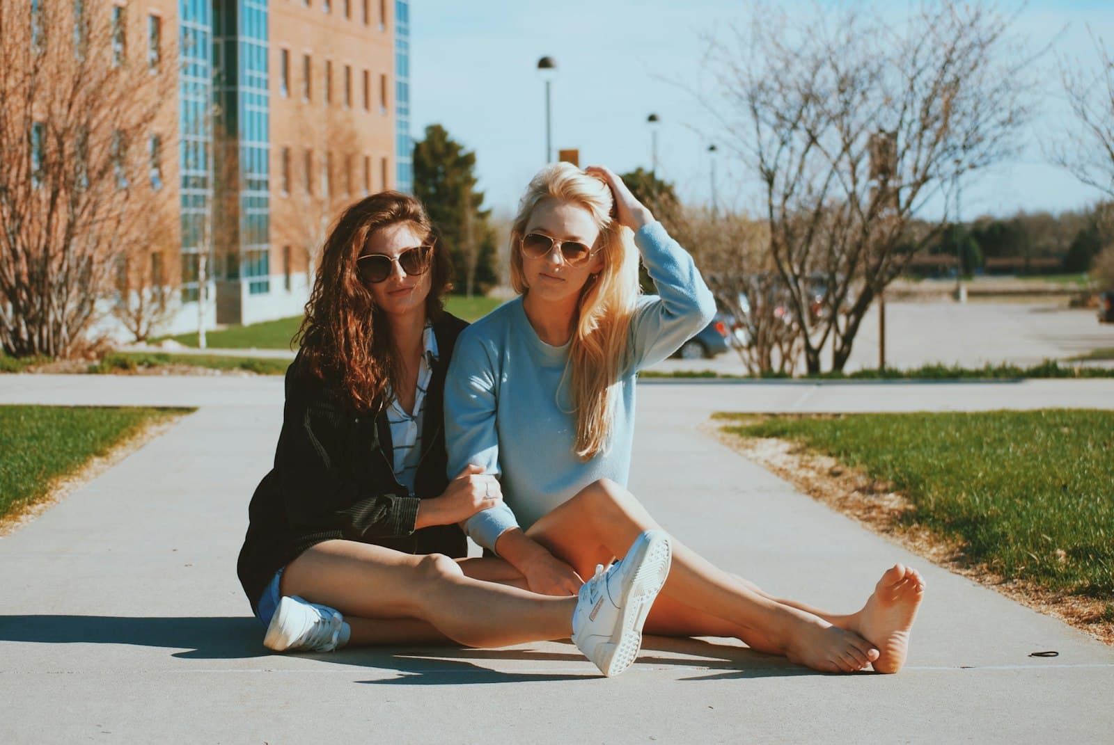 Two friends sitting close together on a campus path